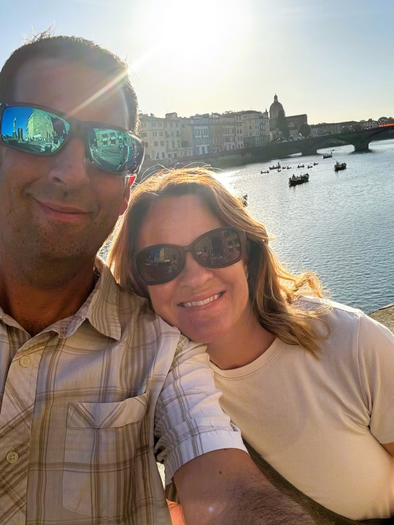 smiling couple with buildings in rome in background
